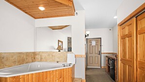 Un baño moderno con tocador de madera, una bañera amplia y zona de ducha.