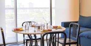 A dining area with a round table, chairs, and a pitcher of water.