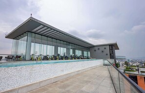 A modern building with a glass facade, a rooftop pool, and outdoor exercise equipment. - Stay Close to Guadalajara's Best Spots (Guadalajara)