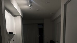 A modern kitchen with a built-in oven and sink, a dining area with a table and chairs, and a view of the city at night through a large window. - "Chic Retreat: Pet & Smoke-Friendly, Balcony Views, Prime Location!" (Vaughan)