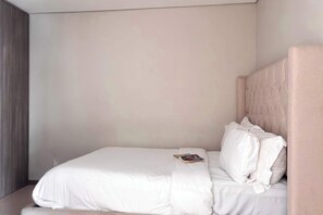 A single bed with a headboard, white bedding, and a magazine on the bed. - 2BR Near Andares | Stunning City Views (Guadalajara)