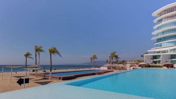 Ein modernes Hotel mit Pool, Strand und Meerblick.
