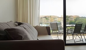 Relax in style with a comfortable sofa and dining area, plus a balcony offering a cityscape view.