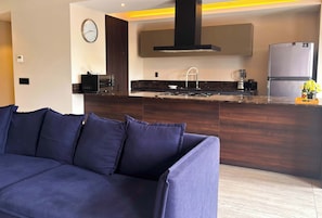 Una cocina moderna con una isla integrada, un refrigerador y un reloj en la pared.