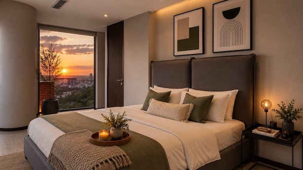 Ein modernes Schlafzimmer mit einem großen Bett, einem Nachttisch, einer Nachttischlampe und gerahmten Kunstwerken an der Wand.