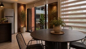 Un comedor moderno con una mesa redonda, sillas y plantas en macetas.