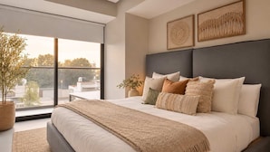 A modern bedroom with a large bed, a view of the outdoors, and two wall-mounted artworks. - Stay Close to Chapultepec & Downtown (Guadalajara)