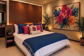 A bedroom with a bed, a nightstand, a wardrobe, a large floral painting, and two potted plants.