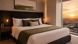 A modern bedroom with a large bed, a city view, and a minimalist design.