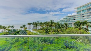 Un hotel de varios pisos con piscina y palmeras.