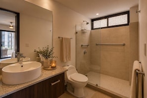 Ein modernes Badezimmer mit großem Spiegel, zwei Waschbecken, Toilette und einer begehbaren Dusche.