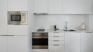 Eine moderne Küche mit eingebauten Geräten, einer Edelstahl-Spüle und einem kompakten Grundriss.