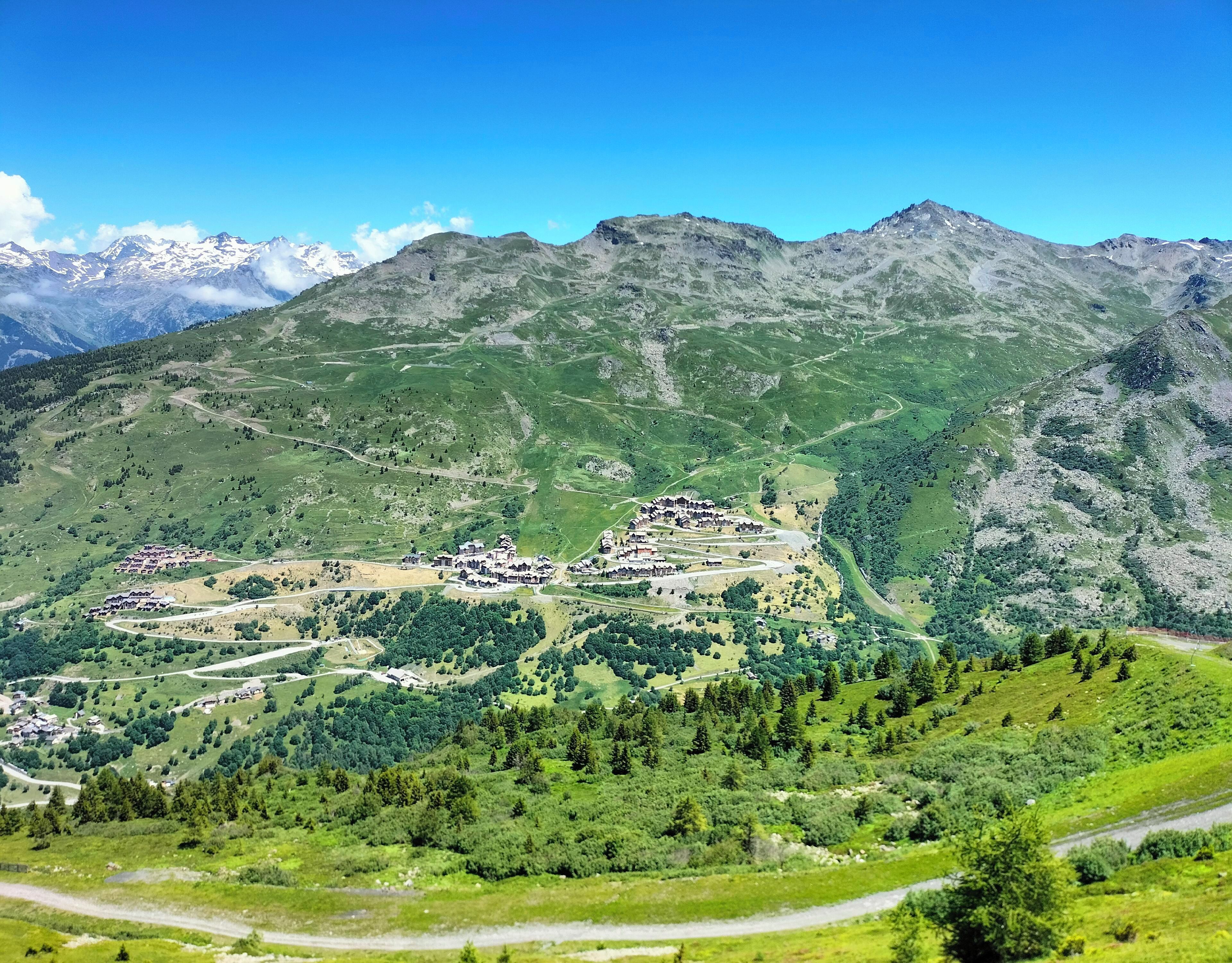 Un paisaje montañoso con un pueblo enclavado en un valle.