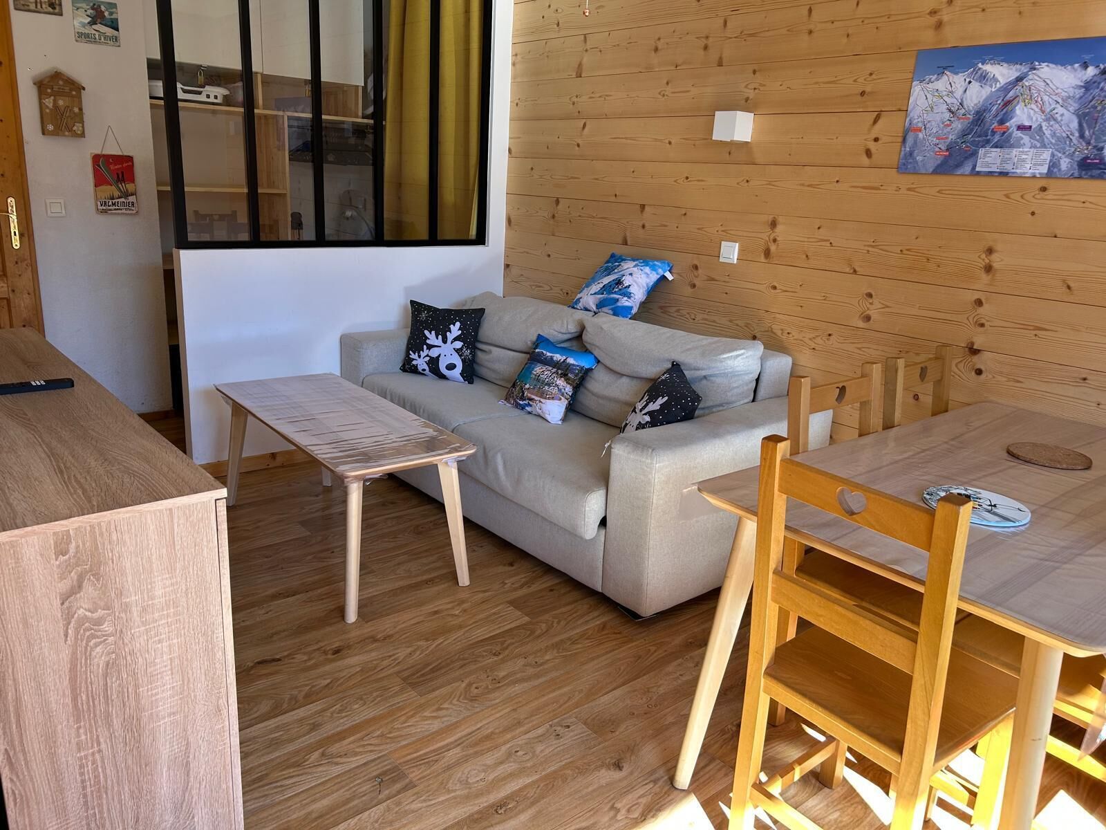 Un área de estar acogedora con un sofá, una mesita y suelo de madera.