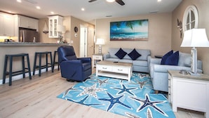 A living room with a sofa, a recliner, a coffee table, and a star-patterned rug. - Coastal Accents and Charm (Sanibel)