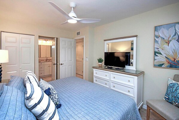 A bedroom with a bed, a dresser, a television, and a painting on the wall. - Island Paradise a minutes walk to the Beach (Sanibel)