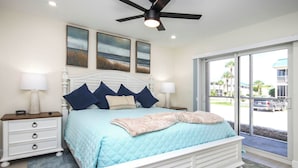 A bedroom with a bed, nightstands, a ceiling fan, and a view of the outside. - Radiant Unit C4 · Sanibel Arms West | Gulffront Panoramic Gulf Views (Sanibel)
