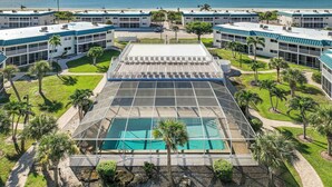 A hotel with a pool, palm trees, and a view of the ocean. - Spectacular Unit C5 · Sanibel Arms West | Gulffront Endless Gulf Views (Sanibel)