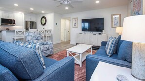 A modern living room with a TV, sofas, and a ceiling fan. - Spectacular Unit C5 · Sanibel Arms West | Gulffront Endless Gulf Views (Sanibel)