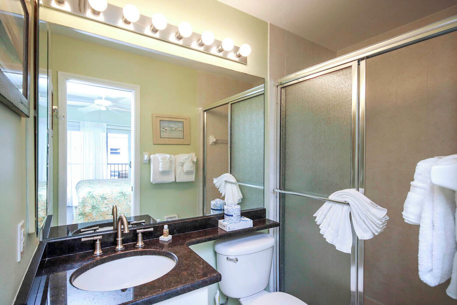 Une salle de bain équipée d’un lavabo, de toilettes et d’une douche à parois en verre.
