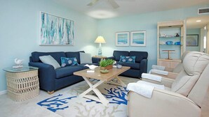 A living room with two sofas, a coffee table, a lamp, and a decorative plant. - Serene Unit G8 Sanibel Arms West Condo | Easy 2 Minute Walk to the Beach (Sanibel)