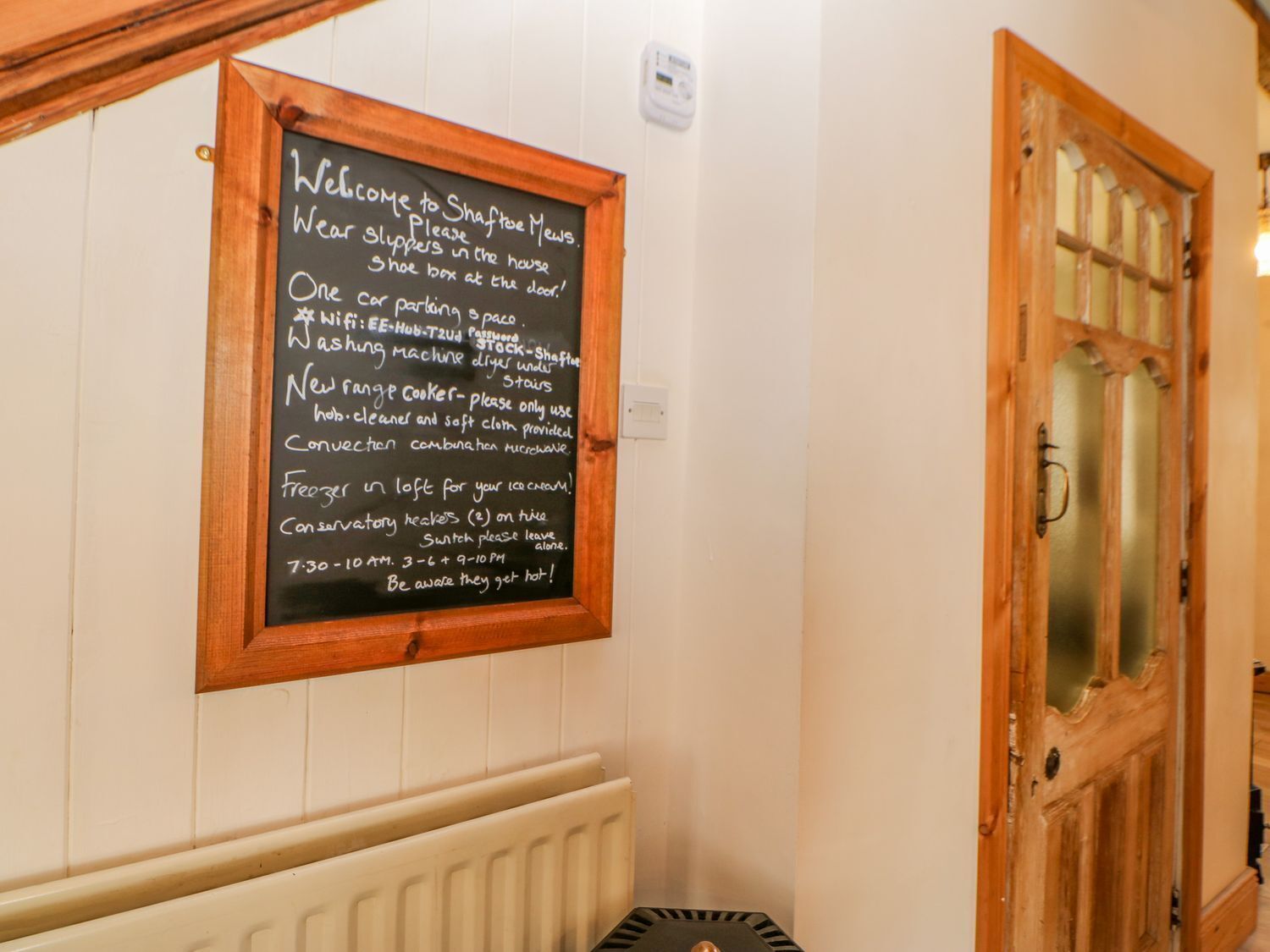 A chalkboard sign with welcome and house rules for a restaurant.