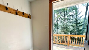 A room with a wooden bench, a coat rack, and a door leading to a deck with a railing. - Private & Relaxing backyard Hot Tub, Fire pit, nap under the trees in a Hammock (Canadensis)