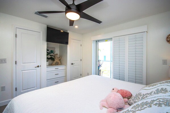 A bedroom with a bed, a ceiling fan, a dresser, and a closet. - Sunny 2BR Sanibel Arms West Garden Unit J1 | Beautiful Retreat to the Gulf (Sanibel)