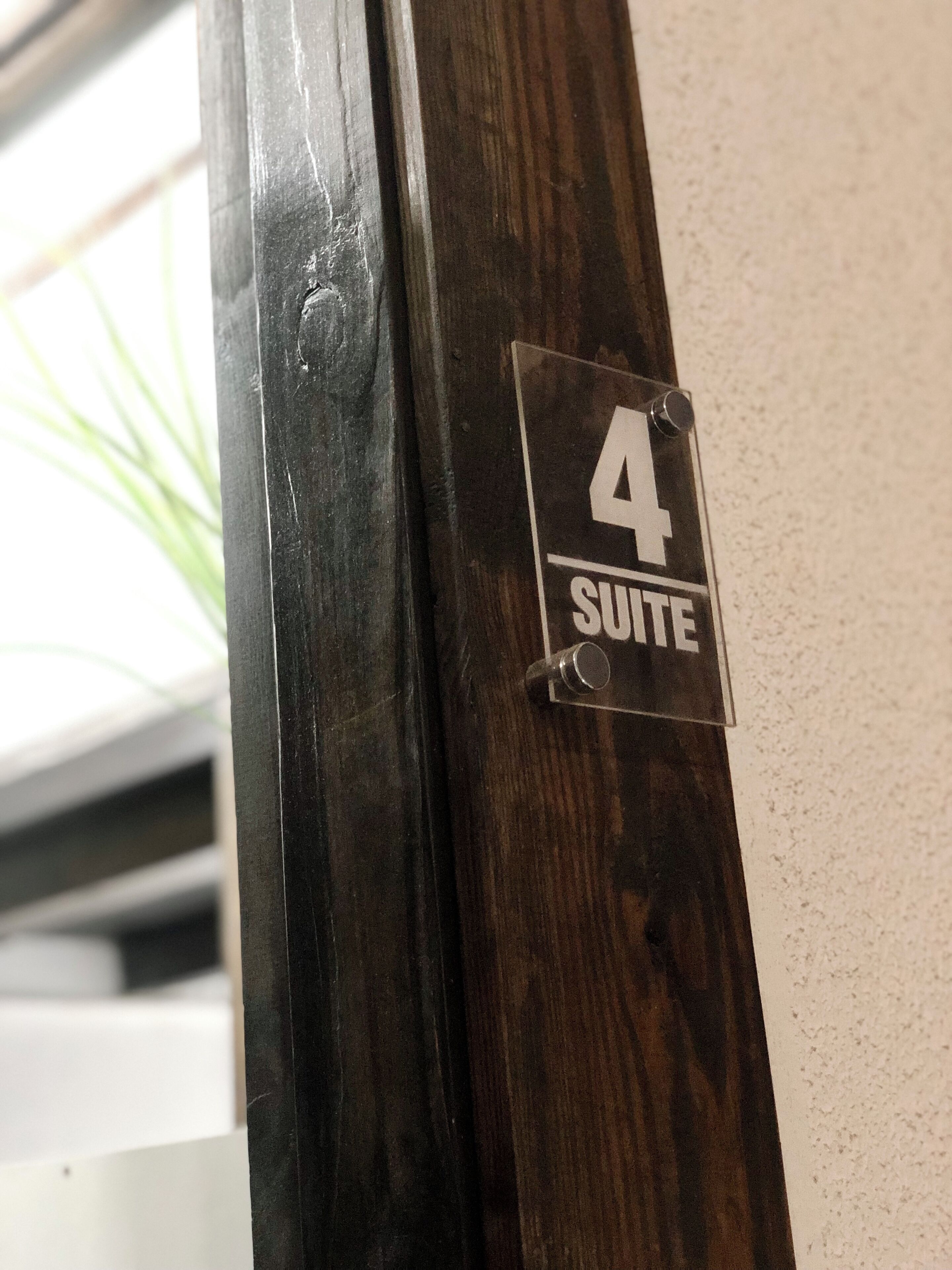 A wooden door with a sign indicating "4 SUITE".