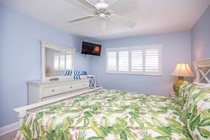 A bedroom with a bed, a dresser, a television, a ceiling fan, and a window with blinds. - Relax in Peaceful Paradise Five Minutes From the Beach (Sanibel)