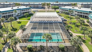 A hotel with a pool, palm trees, and a view of the ocean. - Charming Sanibel Arms West Garden Unit M1 | Short Stroll to White Sand Beach (Sanibel)