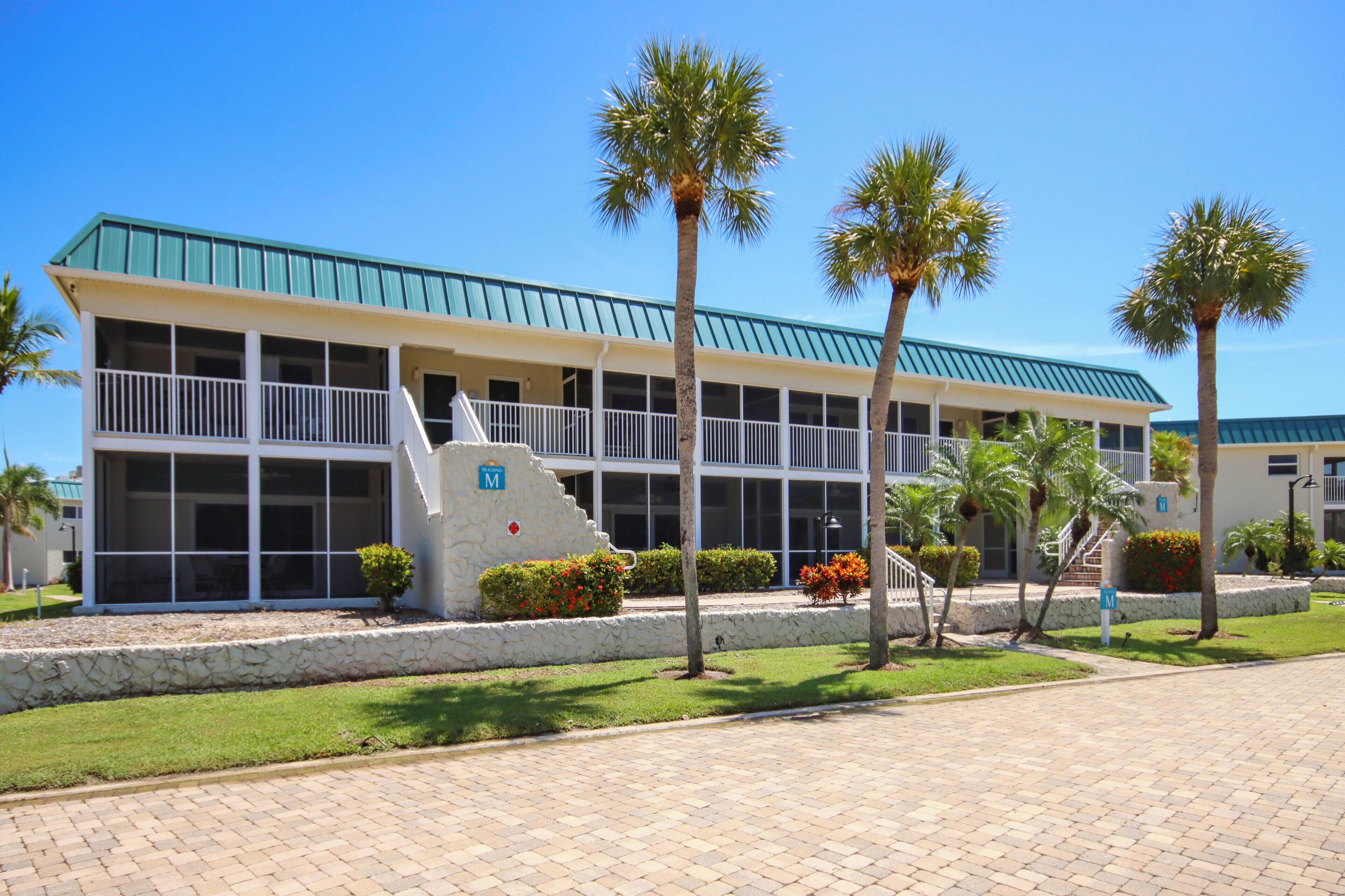 A building with a green roof, multiple windows, and a stone base.