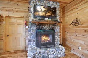 Ein Steinkamin mit einem Fernseher darüber, eine Holztür und eine Steinsäule.