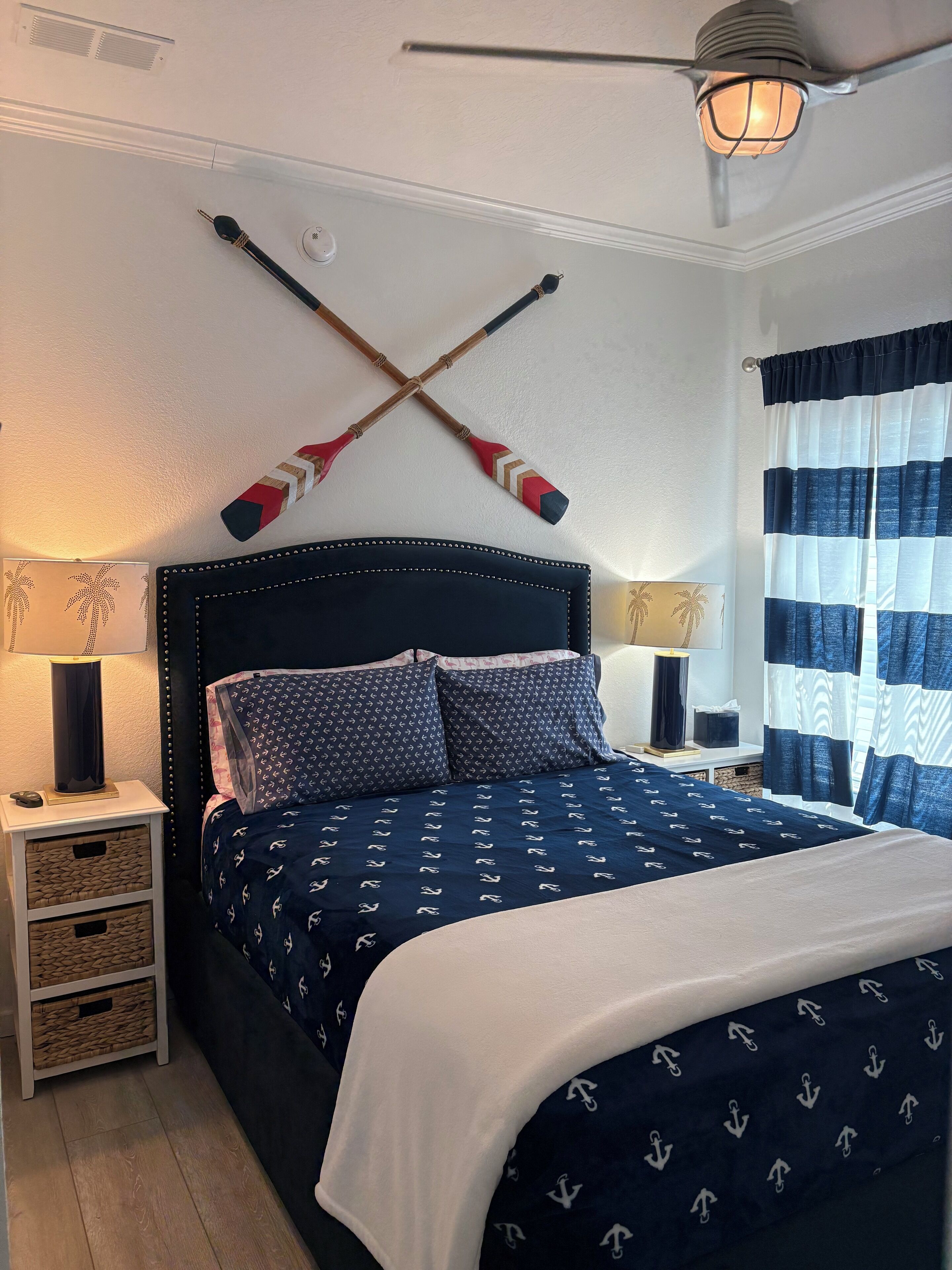 A neatly arranged bedroom with a bed, two bedside tables, a lamp, and a ceiling fan.