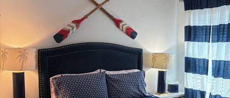 A neatly arranged bedroom with a bed, two bedside tables, a lamp, and a ceiling fan.