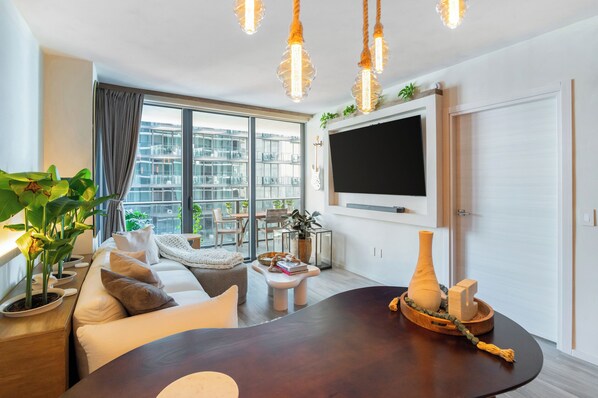 Una sala de estar moderna con un sofá, una mesa de centro y un televisor montado en la pared.