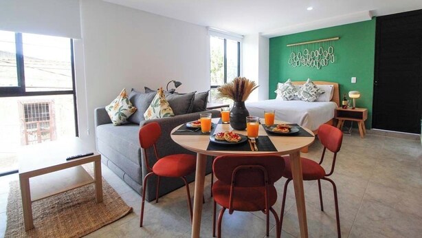 Uma sala de estar moderna com sofá, mesa de jantar e espaço para café da manhã.