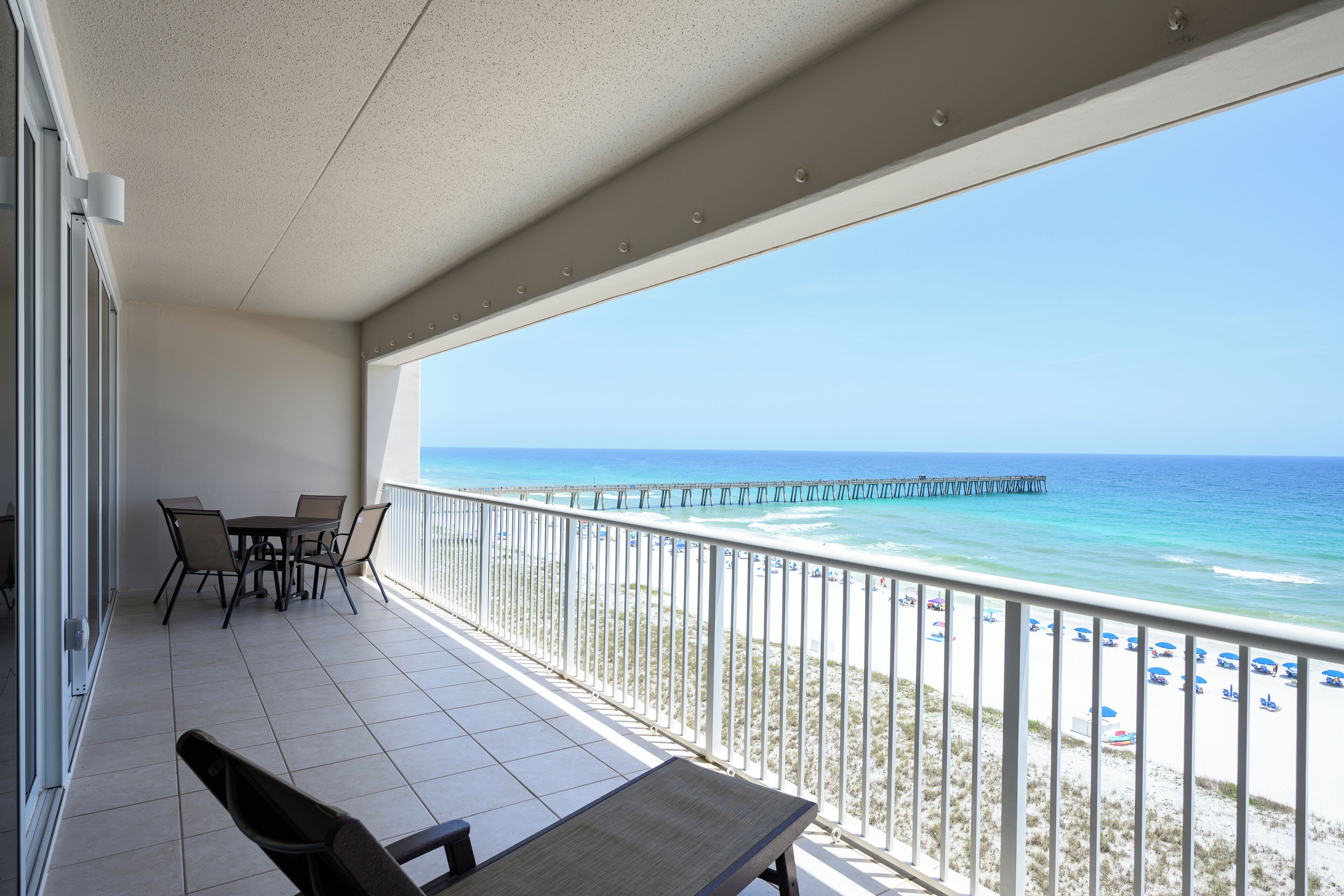 Un balcon avec vue sur la plage et une jetée.