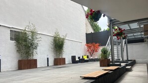 An outdoor patio area with seating, potted plants, and a staircase. - Day8 Hotel  (Cologne)