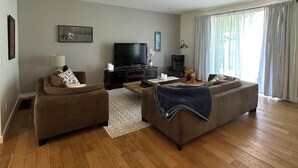 A living room with two sofas, a TV, and a lamp. - Serene Farm Stay (Nanaimo)