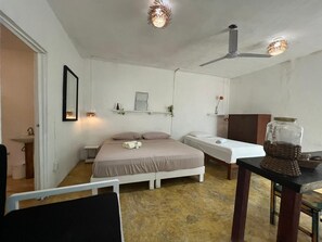 A bedroom with a bed, bedside table, and a ceiling fan. - Casa Selva Arte Bacalar Free Bikes & Kayaks (Bacalar)
