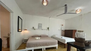 A bedroom with a bed, bedside table, and a ceiling fan. - Casa Selva Arte Bacalar Free Bikes & Kayaks (Bacalar)