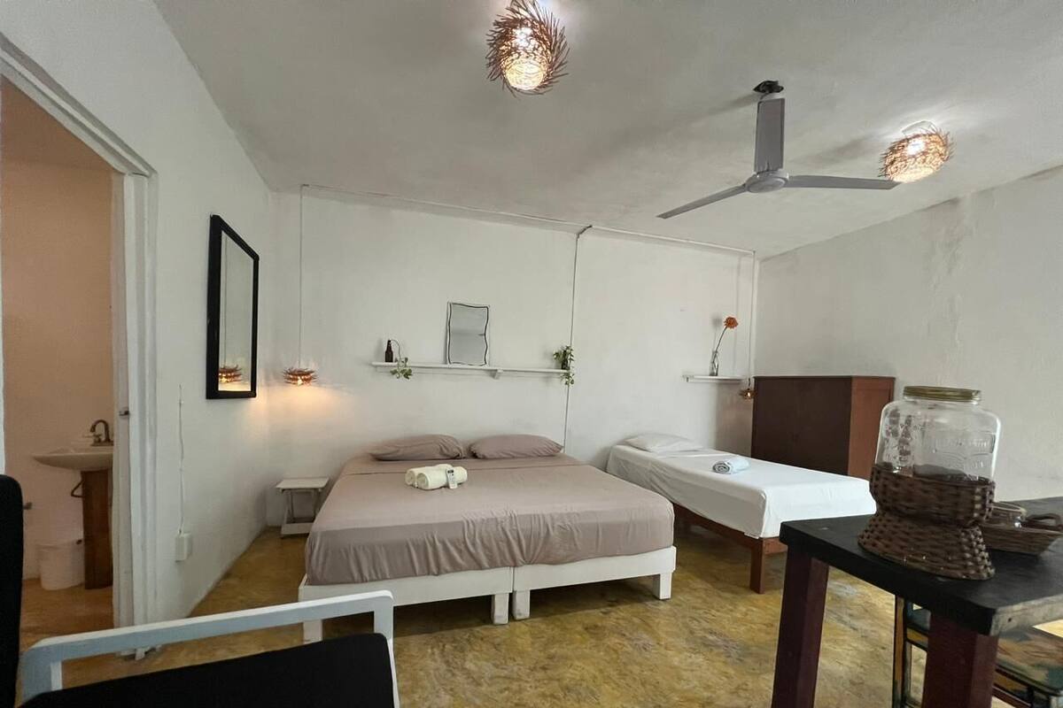 Une chambre à coucher avec un lit, une table de chevet et un ventilateur de plafond.