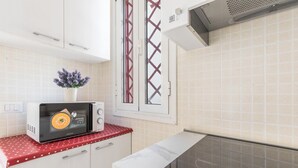 A kitchen with white cabinets, a microwave, and a stove.
