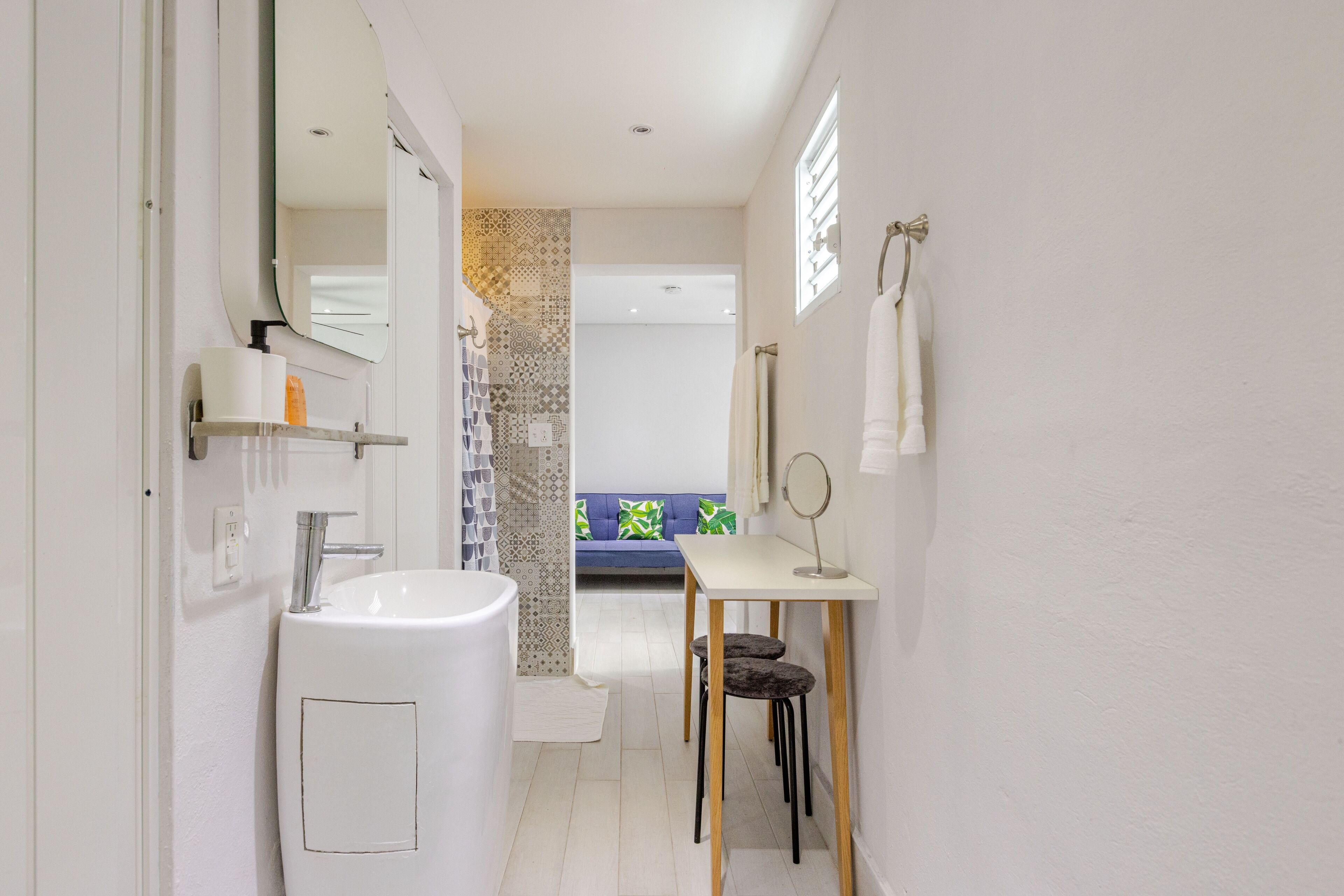 Ein modernes Badezimmer mit Waschbecken, Spiegel und Handtuchhalter.