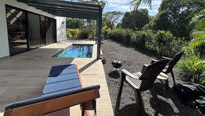 A modern house with a swimming pool, wooden deck, and outdoor seating area.