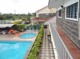 Una piscina con tobogán, piso a cuadros y una fila de sillas.