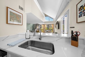 Enjoy meals in this well-equipped kitchen with a large sink, modern faucet, and ample countertop space.