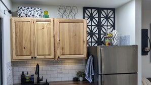 Een moderne keuken met houten kastjes, een koelkast van roestvrij staal en een vaatwasser.