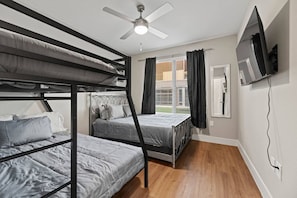 2 habitaciones, escritorio y tabla de planchar con plancha